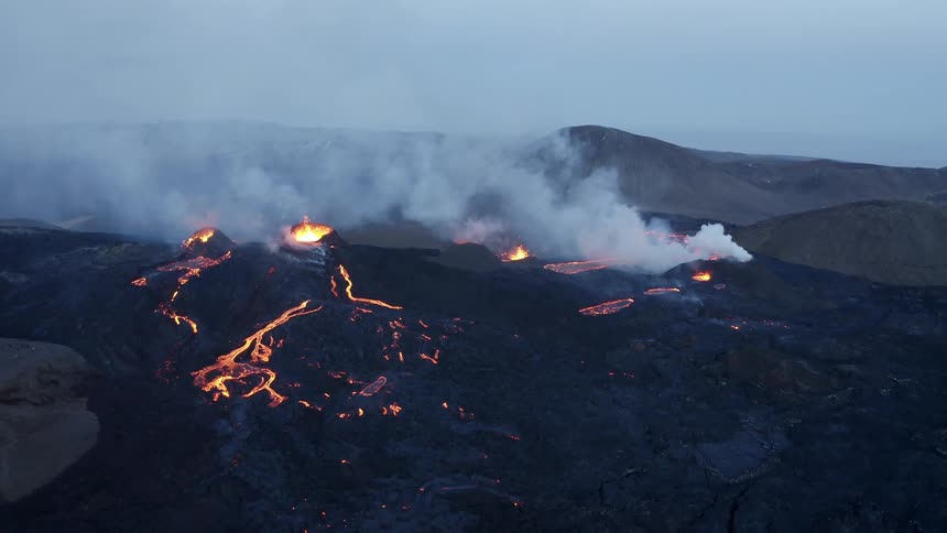 Aerial view of lava erupting from a volcano in the mountains
