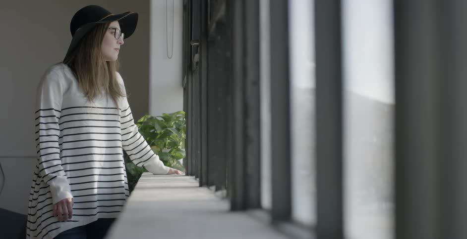 A woman is looking out of a line of windows