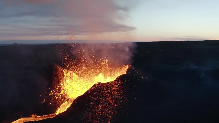 Volcano erupting lava in the morning with a pink sky