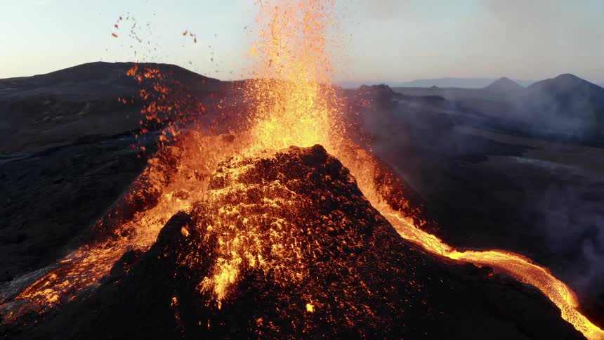 An erupting volcano is spewing magma in small explosions