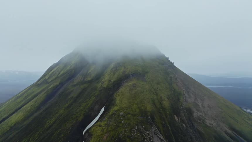 Aerial view of a tall and majestic mountains with a jagged peak that pierces the clouds