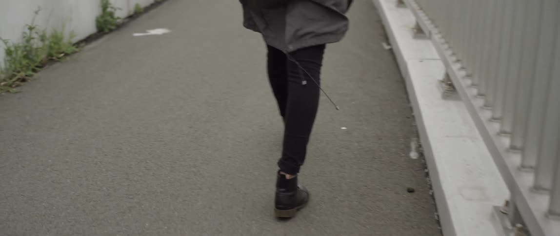 A person walks on pavement on an overcast day