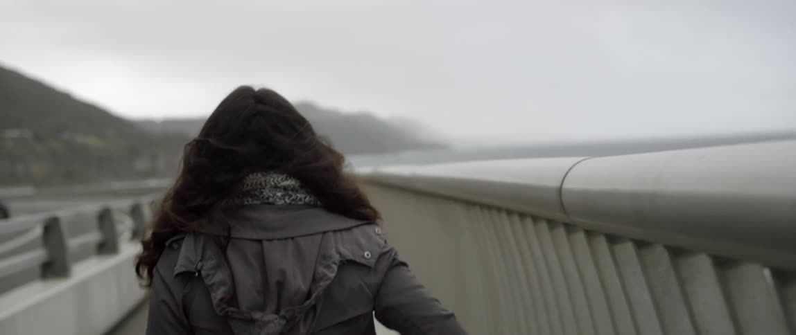 Woman walks outside on a cloudy and breezy day
