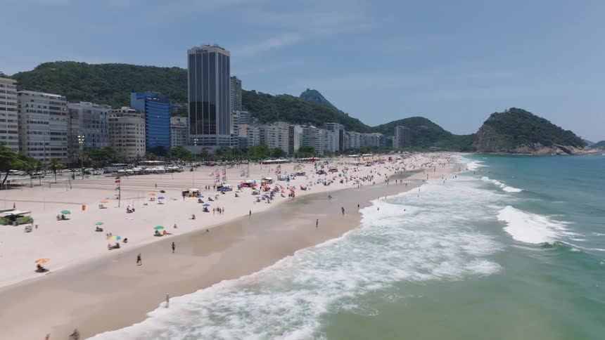 Aerial of people relaxing on a beach in a resort area on a sunny day