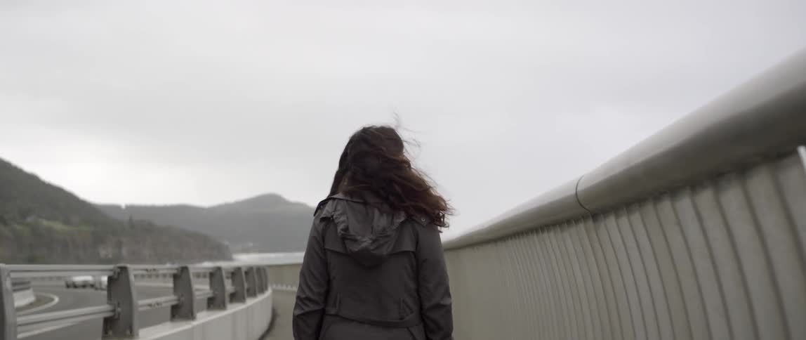 A woman is walking outside on a windy day