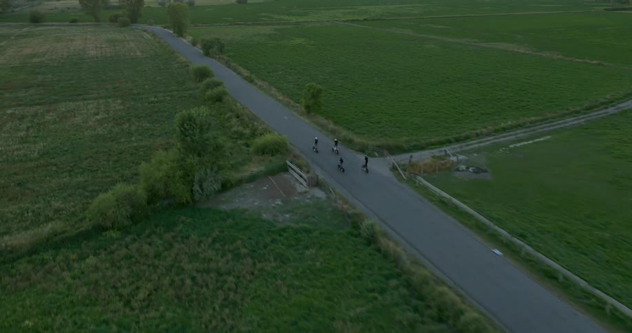People stand on their motorcycles as they race on the road below