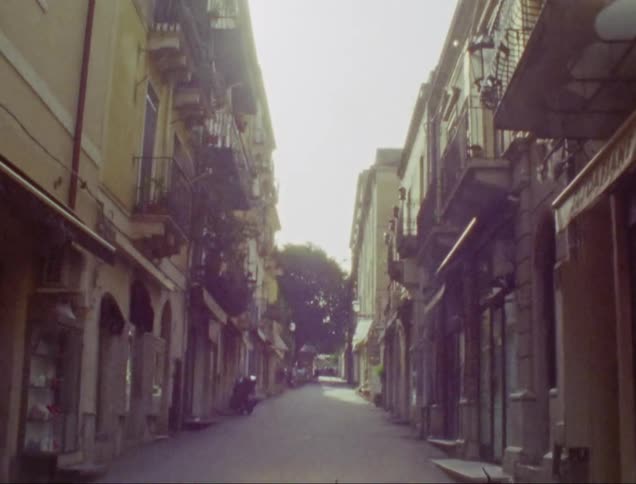 Narrow empty street on a tropical town at morning caught on vintage film
