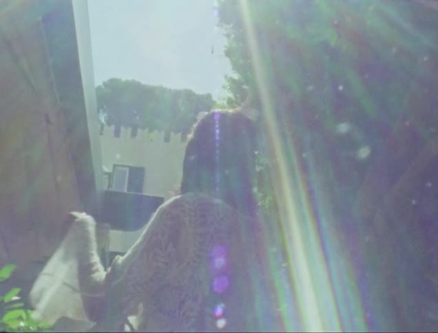 A woman in a white lace dress outside on a sunny day