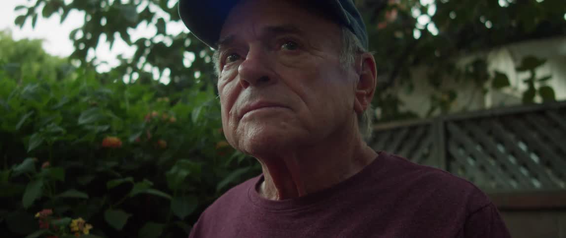Portrait of an elderly man in the backyard of his house with teary emotional eyes