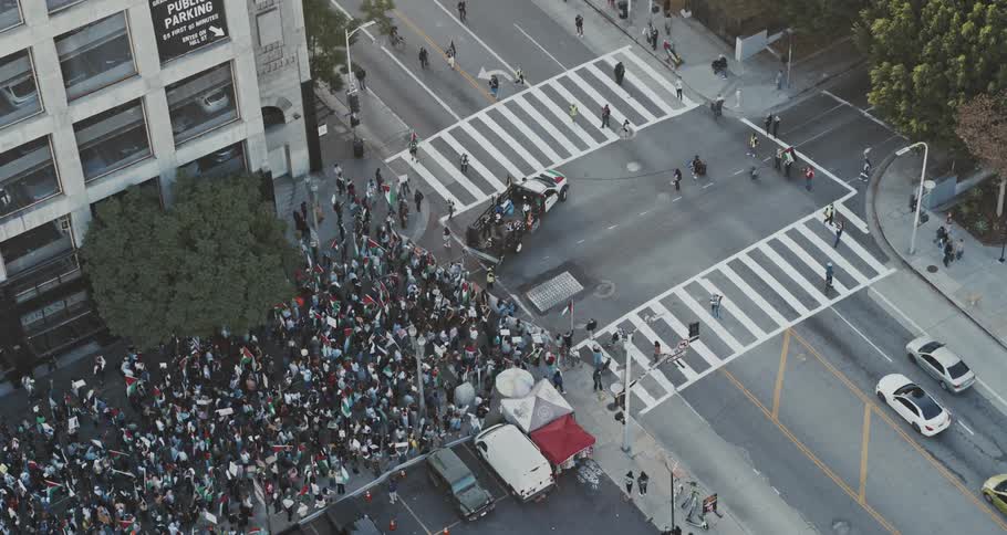 Aerial panorama of a truck leading a crowd of people protesting in the city streets