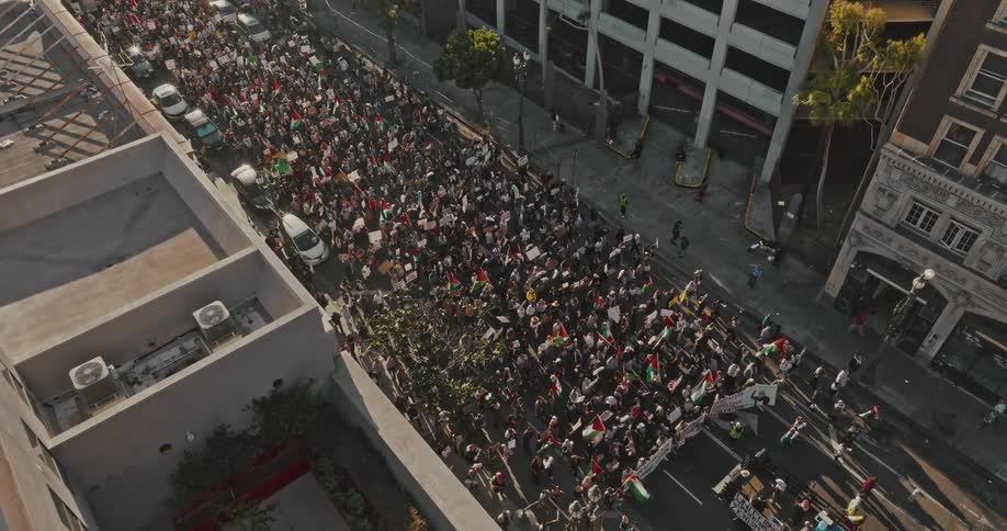 Crowd of people with signs protesting in the city streets