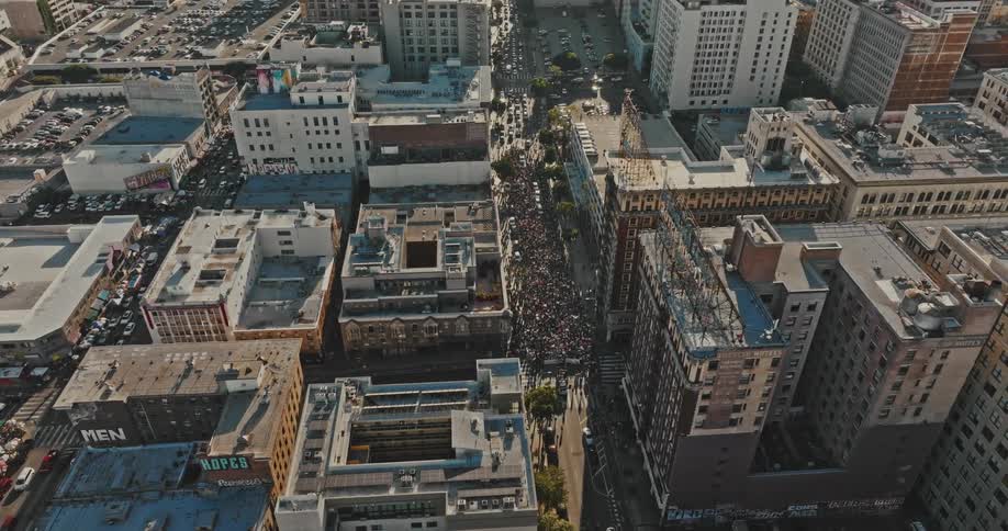 An aerial view of a crowd of people on a street in a city