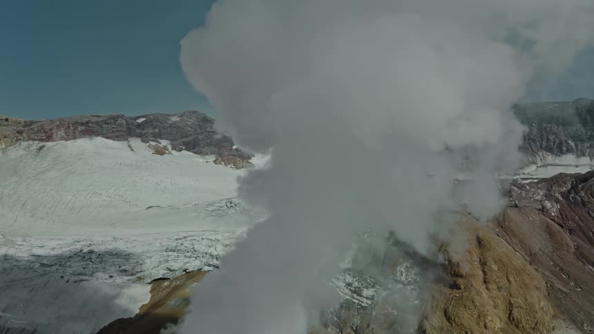 Smoke on the peak of a snowcovered volcanic mountain