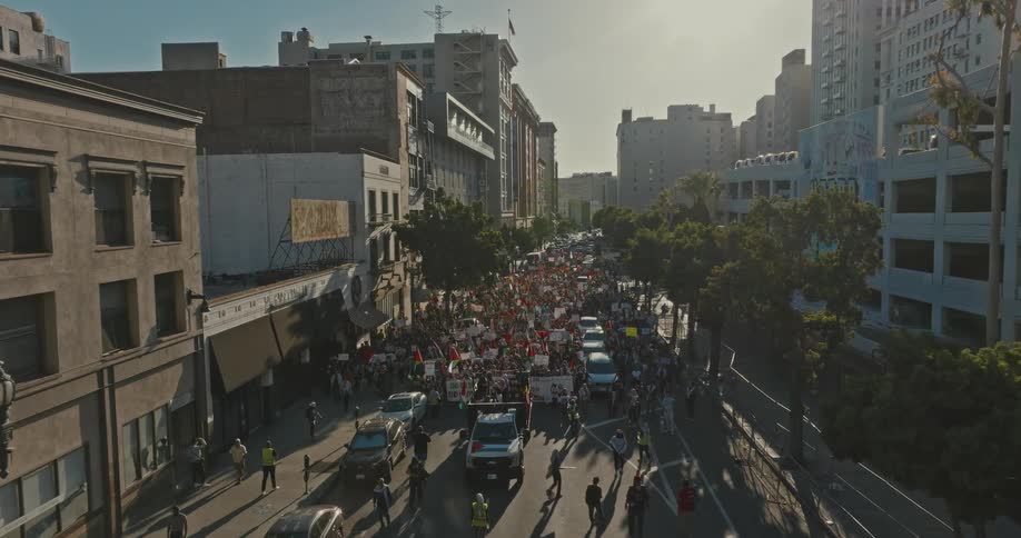 Aerial panorama of a crowd of people with signs protesting in the city streets