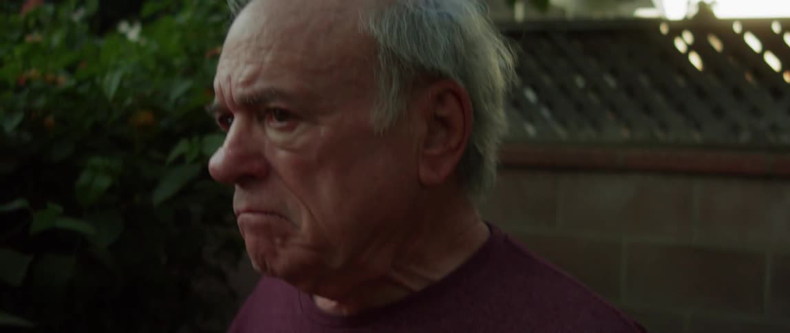 An elderly man with a cap in his hands and a look like he is having memories