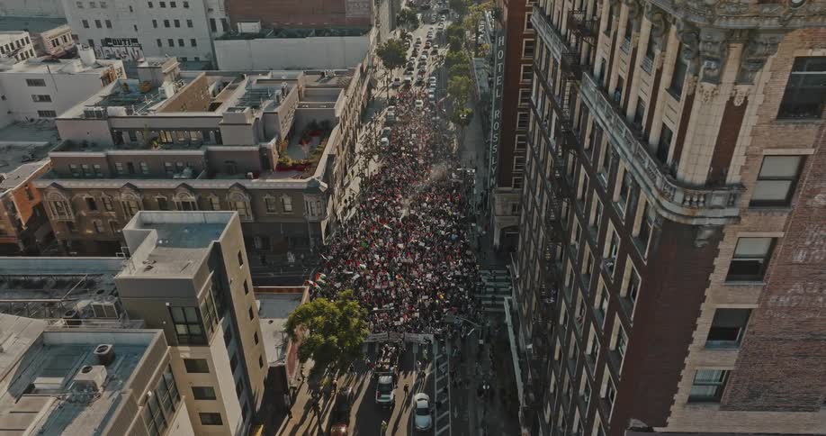 An aerial view of a large crowd gathered in a city street
