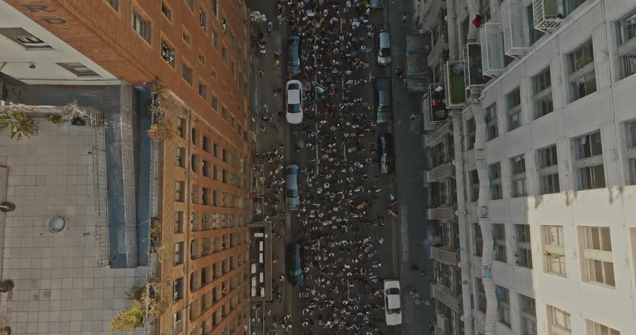 Aerial view of a street between residential buildings with protesters in the streets