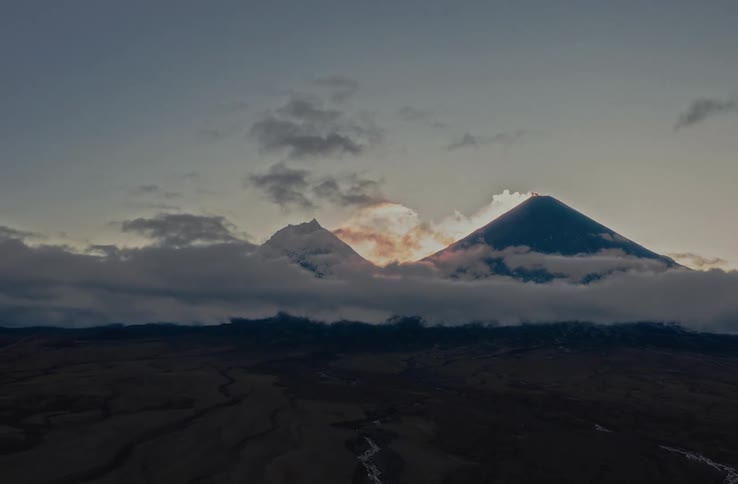 Time lapse of clouds dissipating over a volcano in the morning