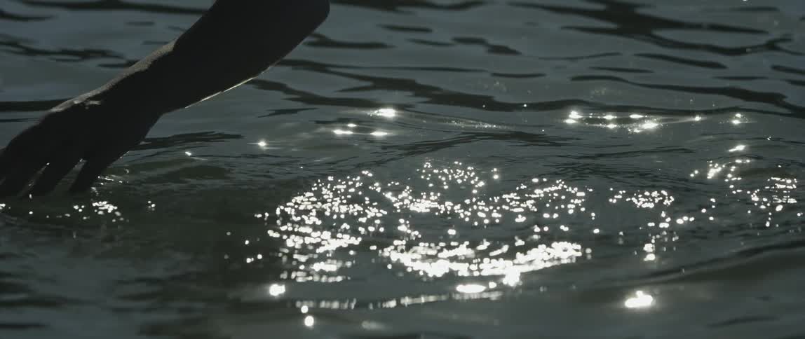 A hand running gently over a water surface