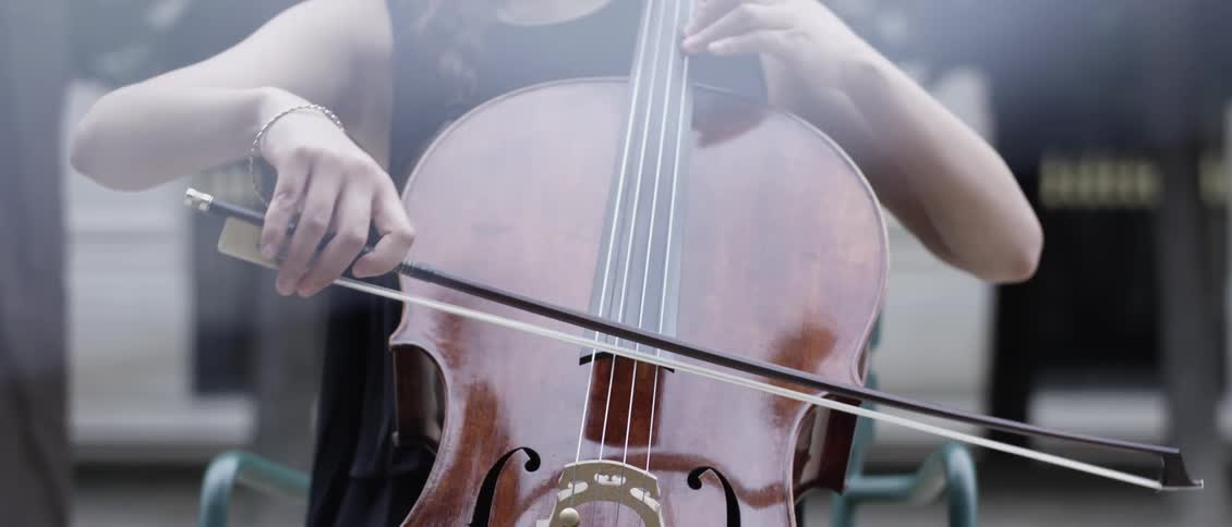 Closeup of a womans hands playing the violin in an outdoor setting
