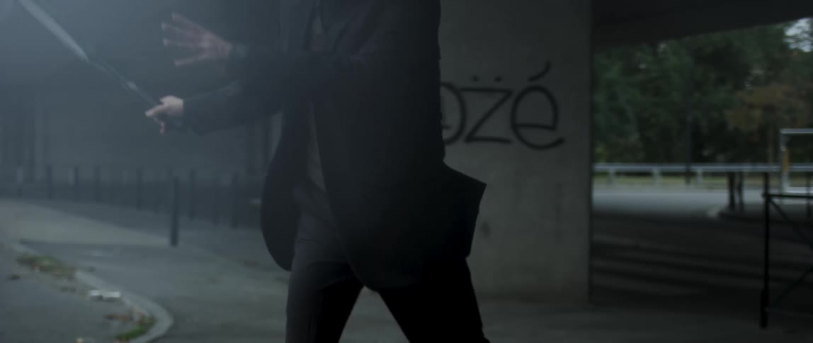 Man in a suit hitting a tennis ball with a racket