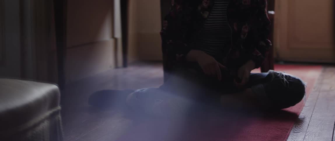 A person throwing a blue marble on the ground
