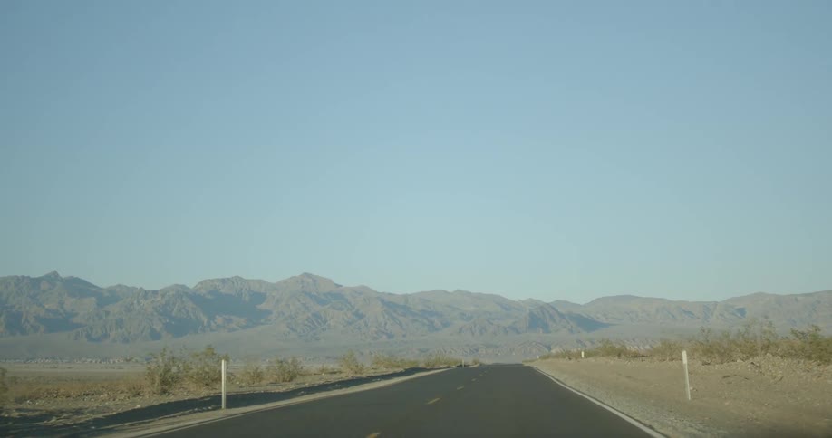 The road stretches towards a mountain ahead