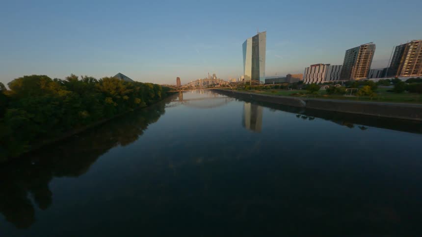 View of a central lake with a bridge in a metropolis under a morning sky