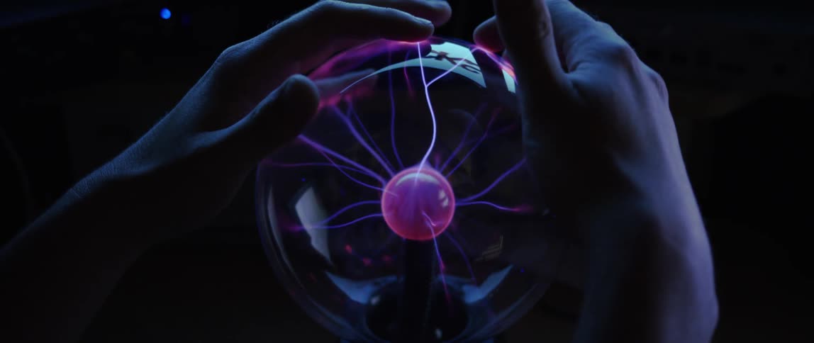 A person puts their hands on the lightning orb