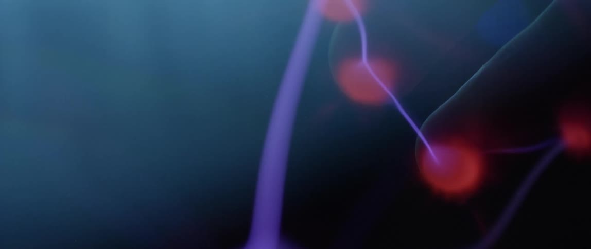 Extreme closeup of an abstract object emitting waves of purple and red lights
