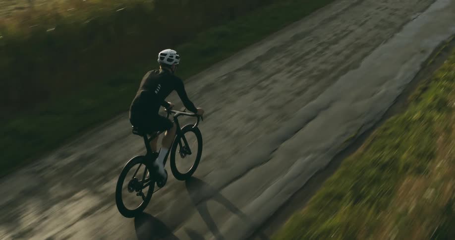 A cyclist riding his bike on an old road on a sunny morning