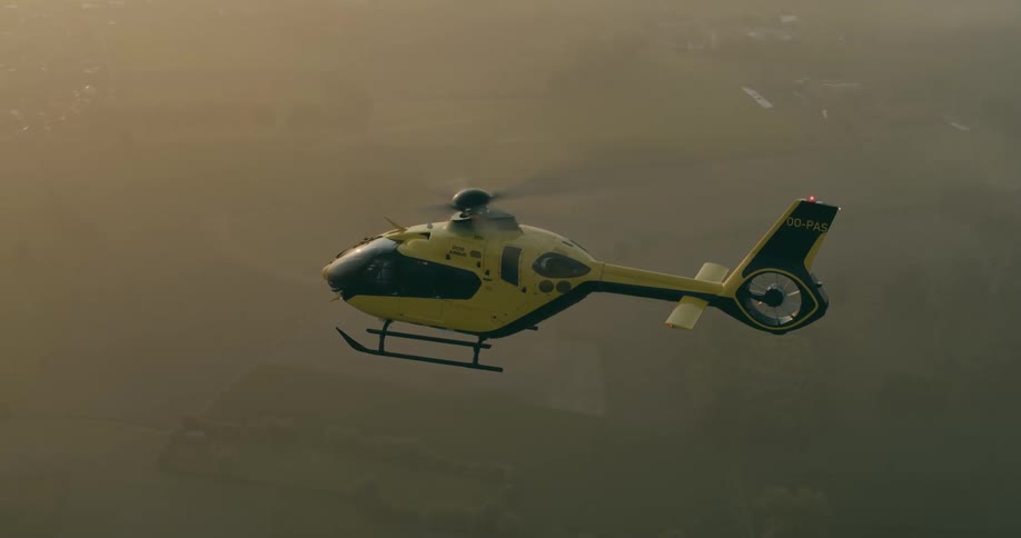 The helicopter flies high through the clouds