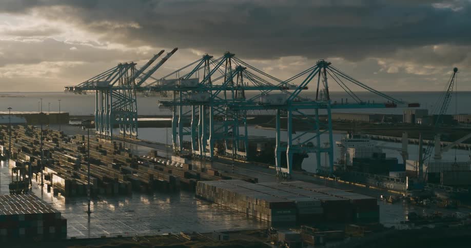 Panorama of a harbor and logistics center by the waterfront with containers and a cloudy sky at dawn