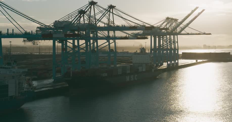 Aerial panorama of cargo ships docked at the port with containers on a morning