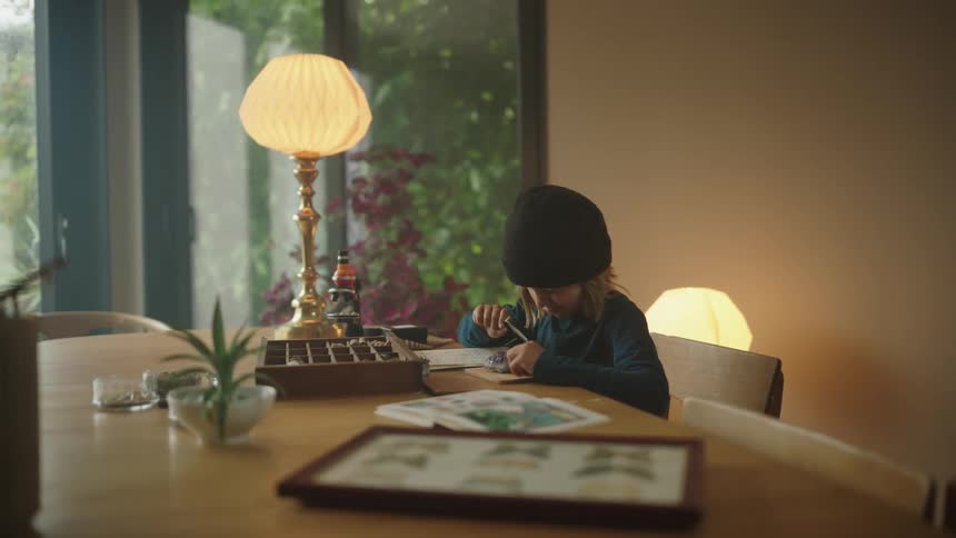 A child is using a magnifying glass to look at a crystal