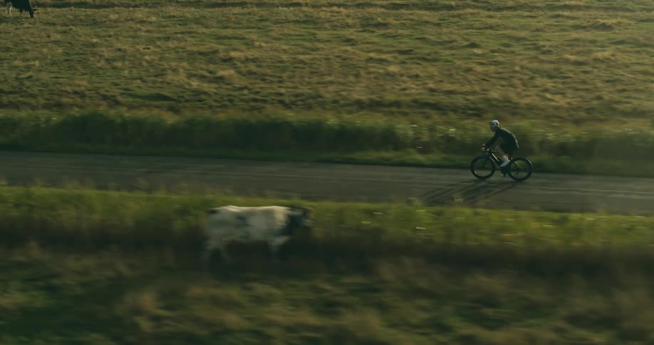 A cyclist pedaling along a deserted country road