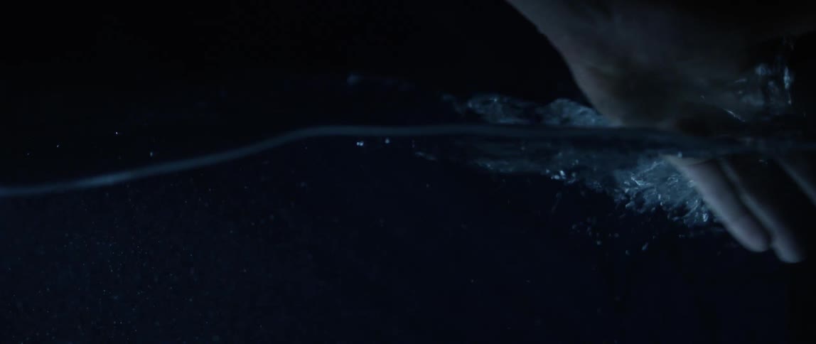 A person splashes the water with their hand