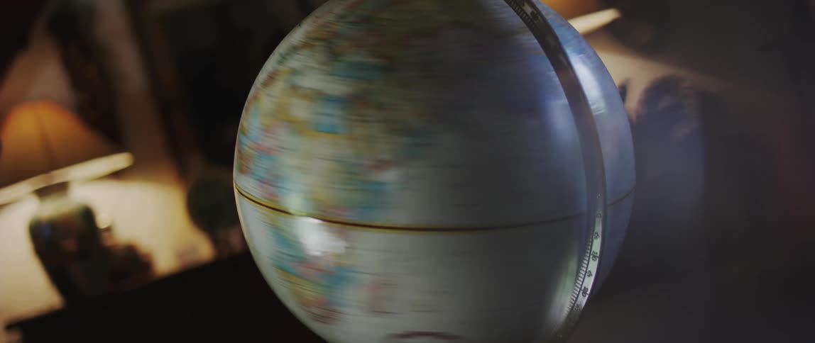 Hand of a man spinning a desktop globe