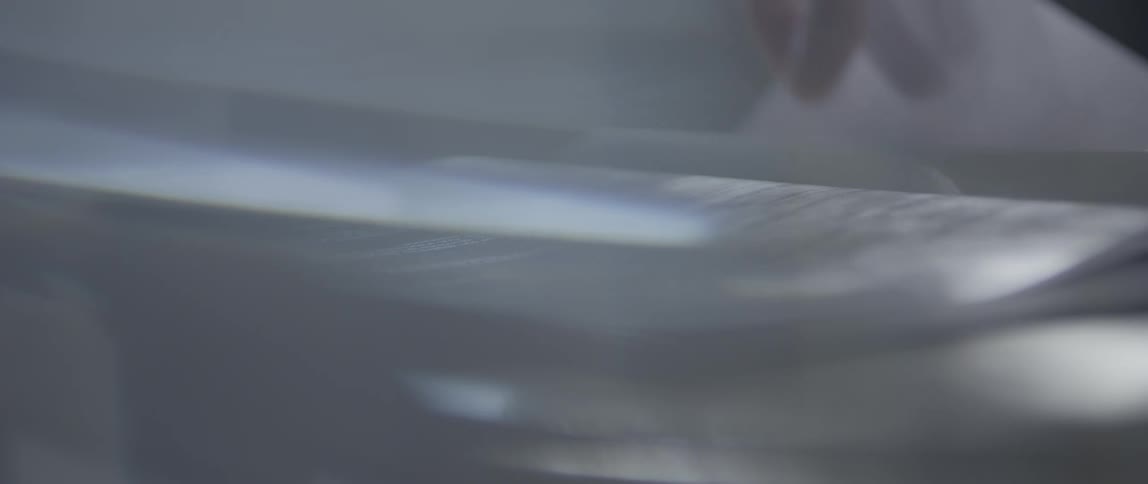 A persons hand turning a page of a book