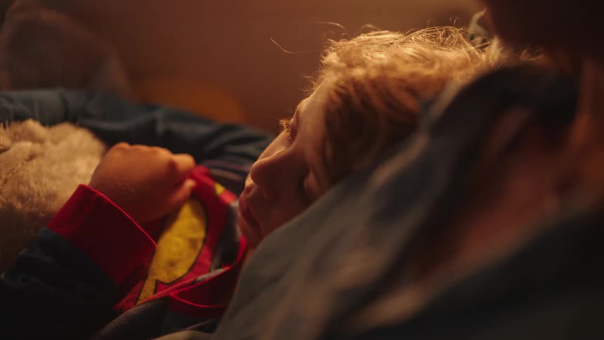 A mother reading a story to her son before bed