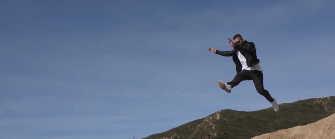 A man runs and jumps off a hill