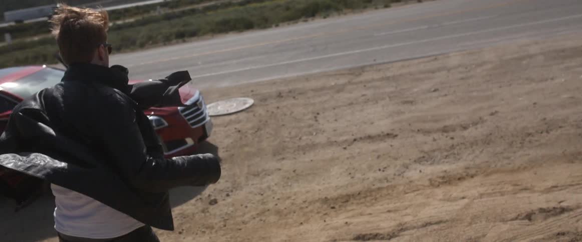 A man runs downhill towards a vehicle