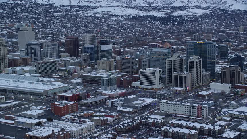Aerial panorama of a metropolis covered in snow with a mountain range on the horizon