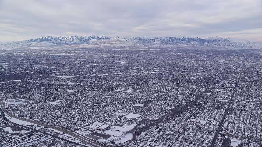 An aerial view capturing a vast snowy cityscape where the white blanket of snow covers buildings streets and the urban landscape
