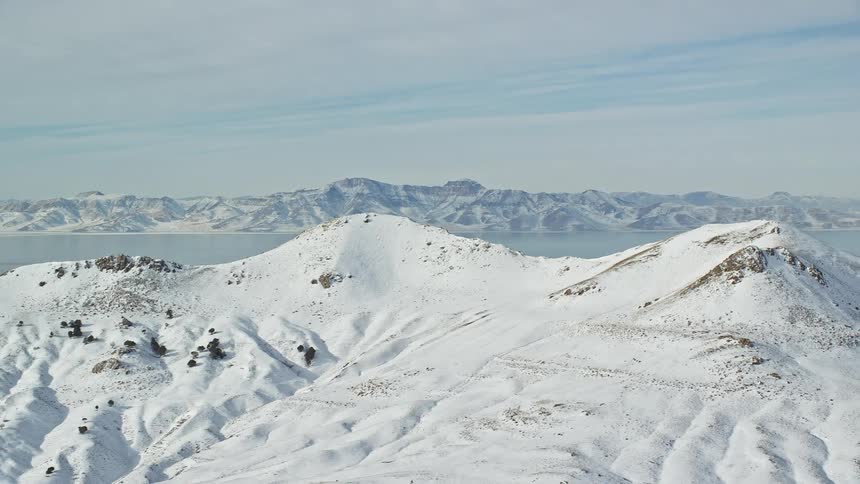 Aerial panorama of a landscape with mountains covered in snow
