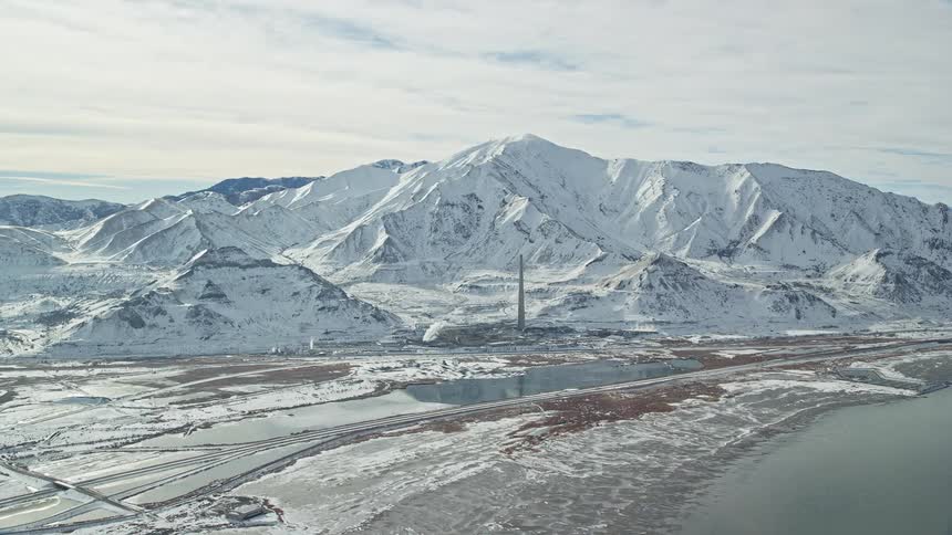 Aerial view of a tower next to snow covered mountains
