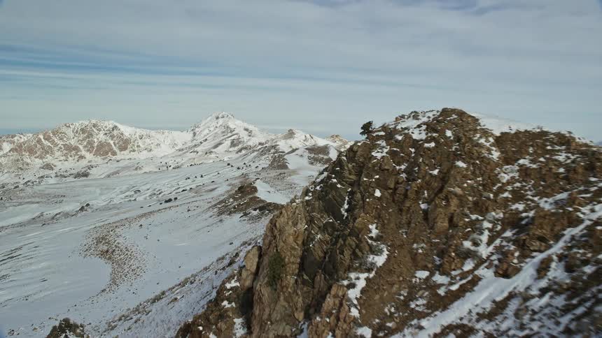 Aerial of frozen mountain range during winter day
