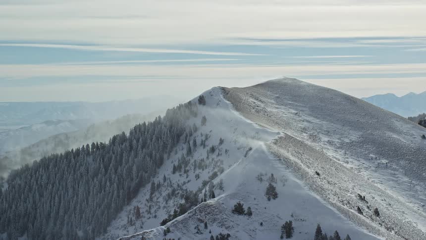 Aerial view of snow covered on mountain slope and its peak