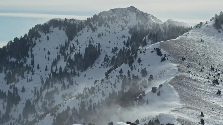 Aerial of snow covered mountain landscape with fog during morning