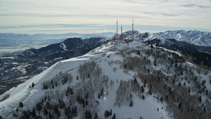 Aerial view of a radio station on the peak of a snow covered mountain